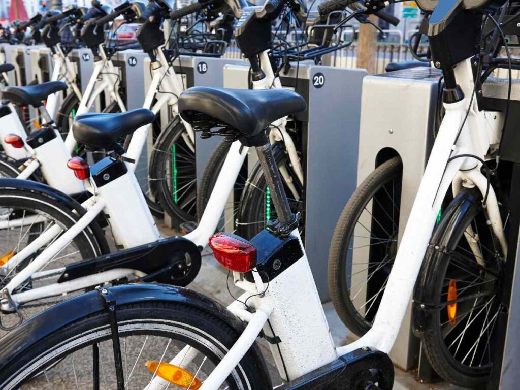 Outdoor bike sharing station with rows of parked bicycles in an urban mobility setting